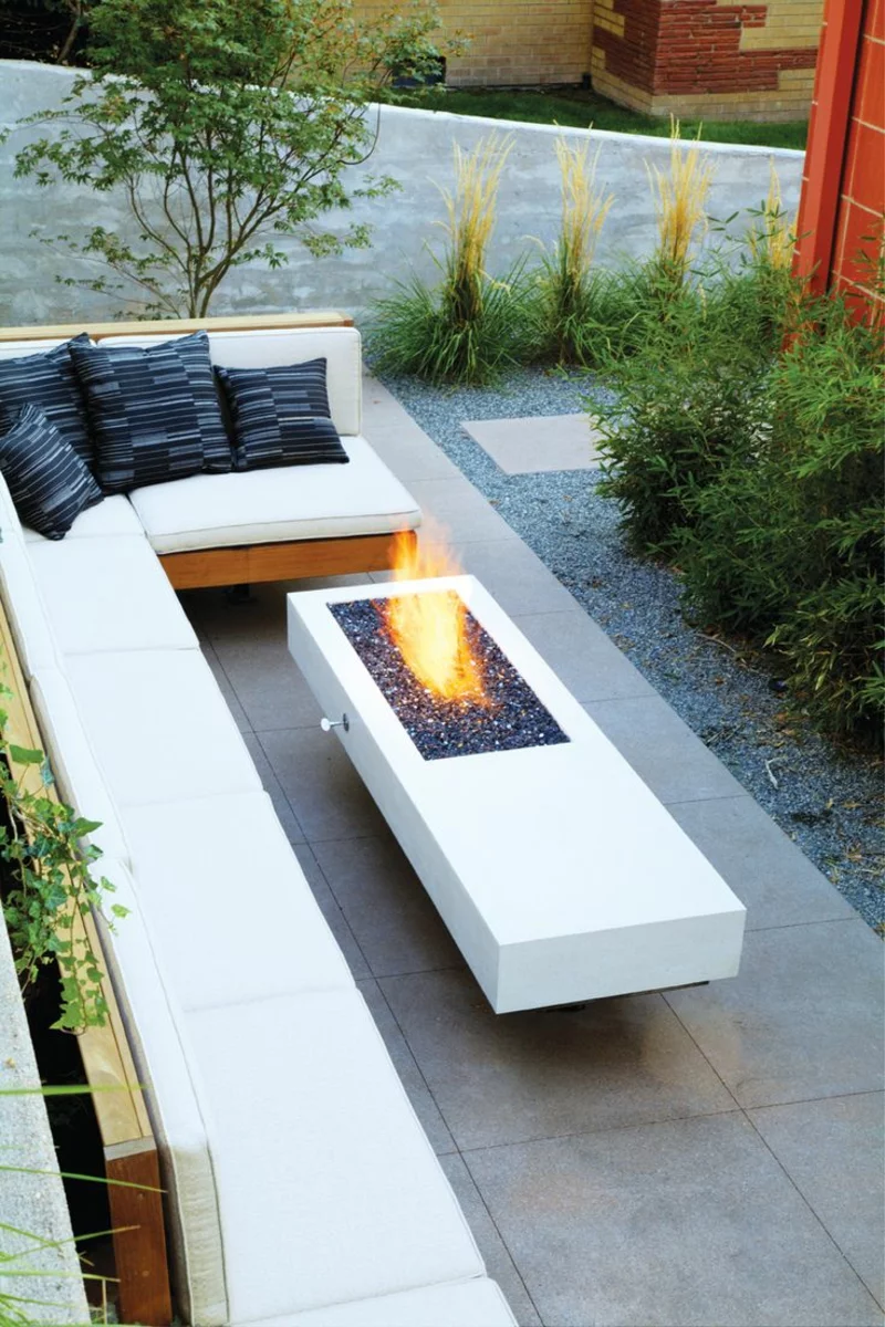 moderne Feuerstelle Gartengestaltung mit Steinen Gartenbank Kissen schöner Anblick