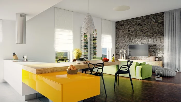 offenes Wohnzimmer mit Steinwand, grünem Sofa und gelber Arbeitsoberfläche
