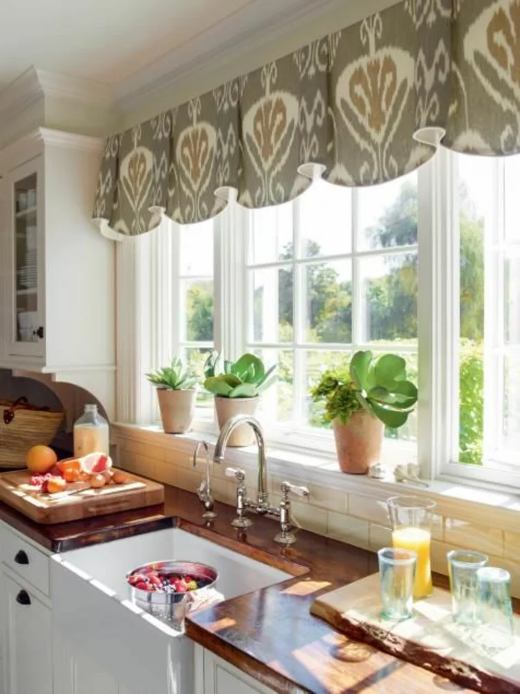 Fensterdeko für die Küche grüne Topfpflanzen auf der Fensterbank und Gardinen am Fenster