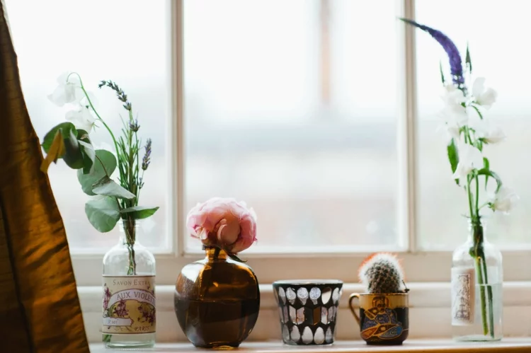 Fensterdeko für die Küche schöne Schnittblumen in Deko Vasen auf der Fensterbank 