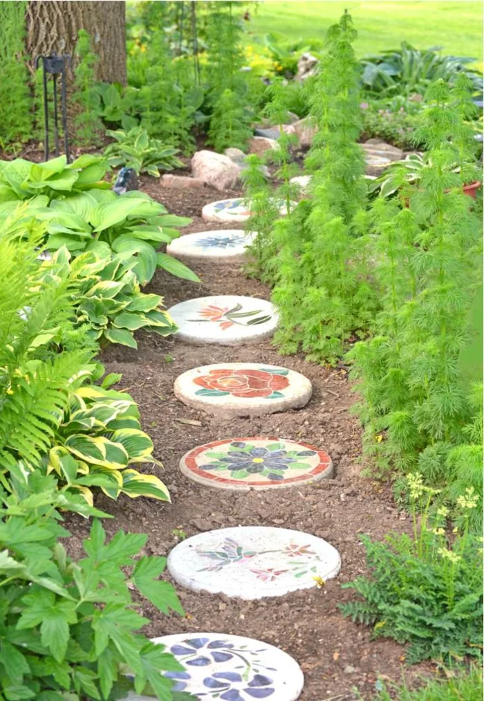Gartenwege gestalten - runde Steinplatten mit Dekoration
