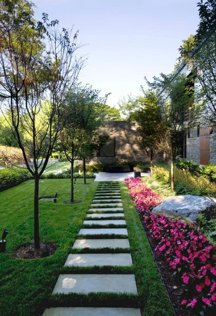 Gartenwege gestalten - Gehwegplatten mit Begrünung und grüner Rasen