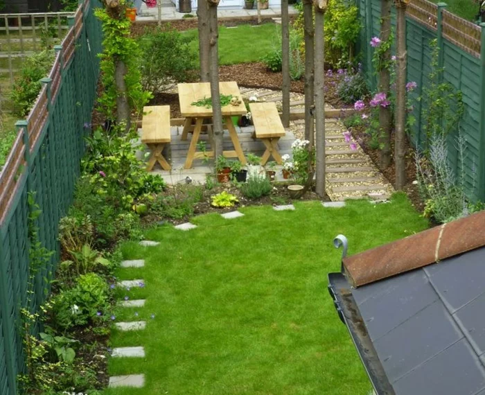 Hinterhof mit grünem Rasen und Gehwegplatten
