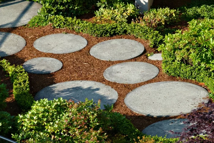 runde Steinplatten und Mulch sind eine moderne Kombination für den Gartenweg
