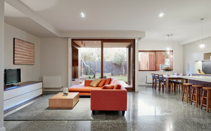modern einrichten offener wohnplan oranges sofa grauer teppich küche absondern