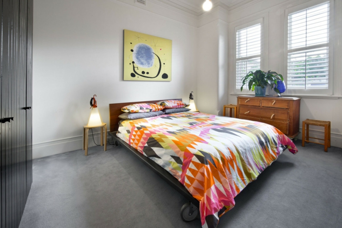 schlafzimmer einrichten beispiele farbige bettwäsche bett räder grauer teppichboden