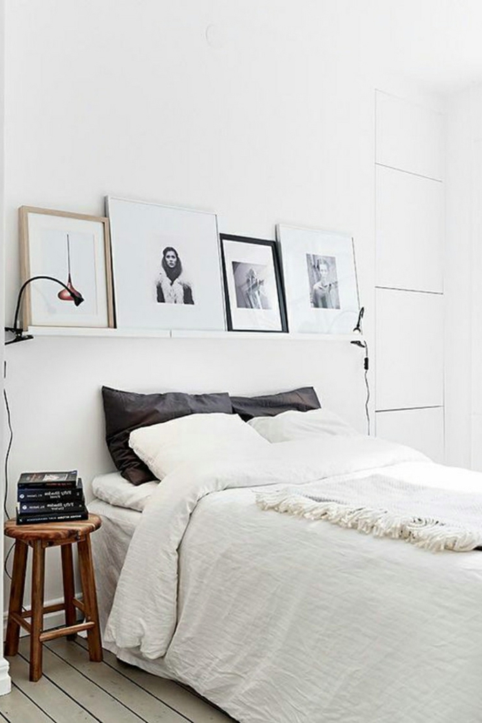 weißes schlafzimmer weiße wände wandregal bilder schwarze dekokissen