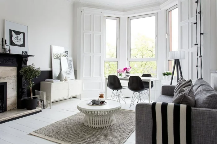 wohnung dekorieren wohnzimmer graues sofa elegantes muster dekokissen schwarze akzentwand