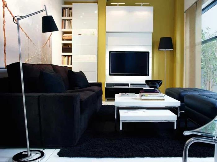 kleines Wohnzimmer mit weißen Bodenfliesen, schwarzem Teppich und grüner Wand