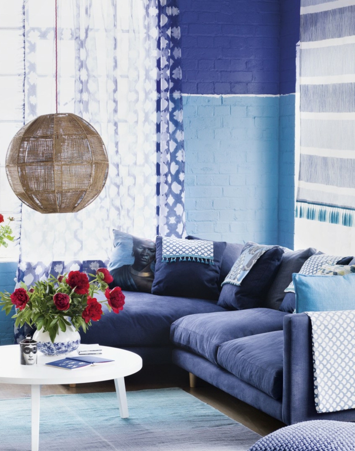 wohnzimmer sofa blau runder tisch blumen hängeleuchte