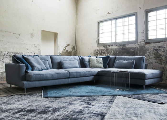 wohnzimmer sofa blau teppiche blaunuancen betonoptik wandgestaltung