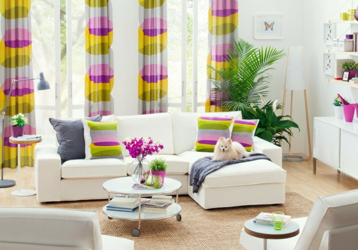 wohnzimmer sofa dekokissen farbige gardinen runder couchtisch räder