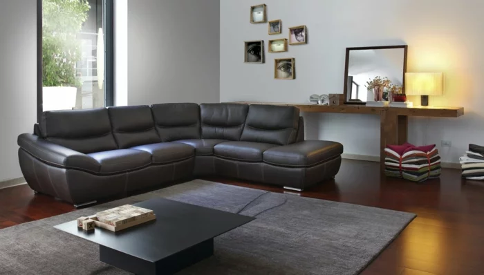wohnzimmer sofa ledersofa schwarz elegant minimalistischer couchtisch grauer teppich fenster