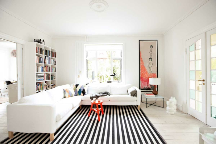 wohnzimmer sofa weiß streifenteppich kleiner beistelltisch weiße wände