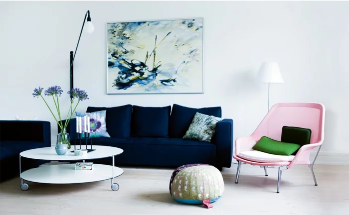 dunkelblaues Sofa, Sessel in Pastellrosa und funktionaler Couchtisch