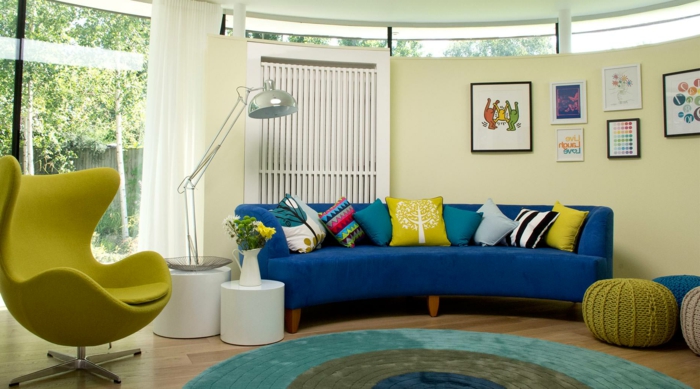 blaues sofa gelber sessel runder teppich farbig hocker weiße gardinen