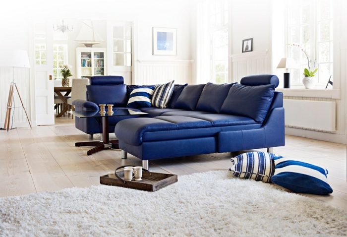 blaues sofa leder weißer teppich holzboden bodenkissen