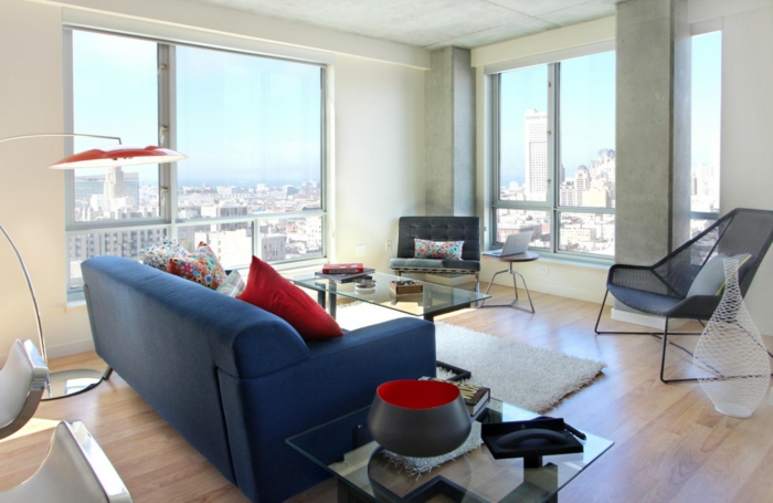 blaues sofa rote akzente weißer teppich gläserner couchtisch panoramafenster