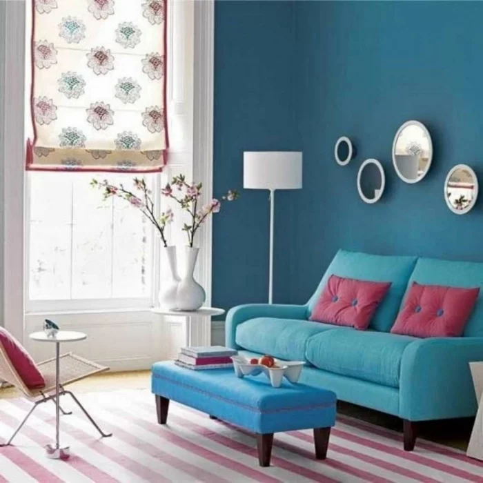 farbiges Wohnzimmerdesign mit blauem Sofa und Streifenteppich