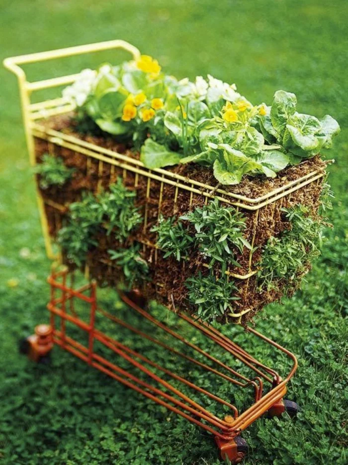 Einkaufswagen als Pflanzenbehälter im Garten