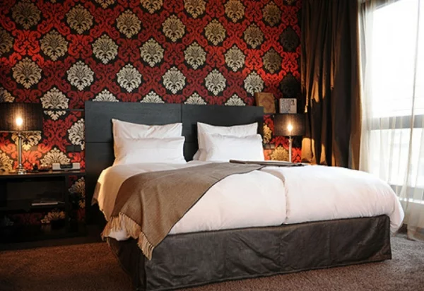 schlafzimmer einrichten klassische mustertapete doppelbett tischleuchten nachtkonsolen