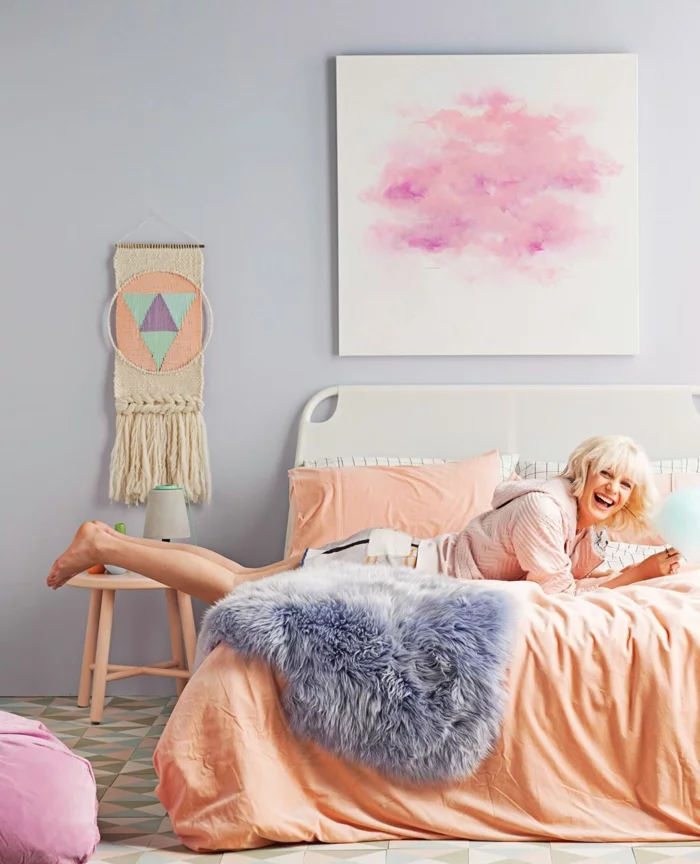 schlafzimmer einrichten pastellfarben orange bettwäsche helle wände geometrischer boden