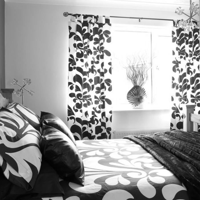 schlafzimmer schwarz weiß bettwäsche gardinenmuster weiße wände coole leuchte