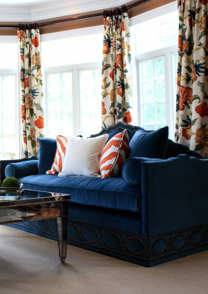 blaues Sofa und farbige lange Gardinen