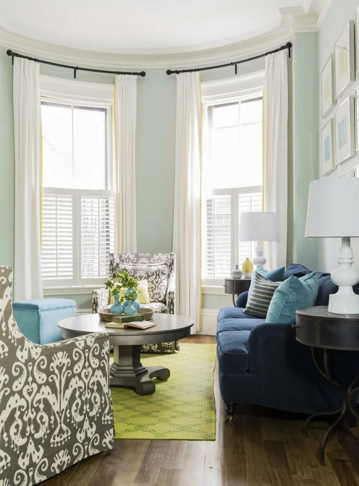 blaues Sofa, grüner Teppich und hellgrüne Wände