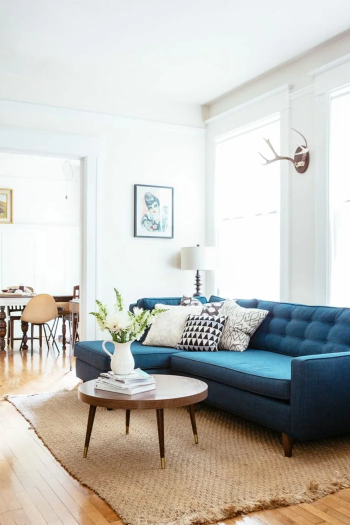 blaues Sofa, Sisalteppich und weiße Wände