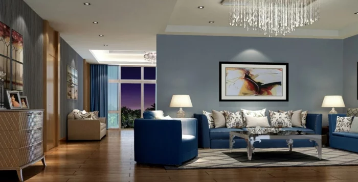 Kronleuchter, blaue Wohnzimmermöbel und graue Wand