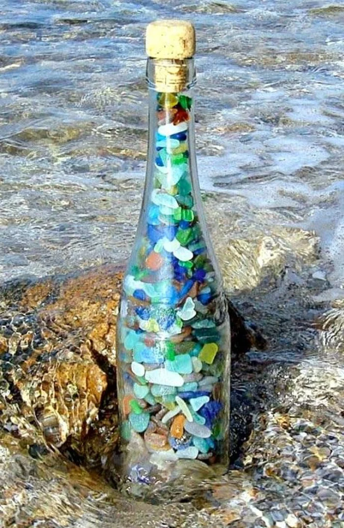Glasflasche mit kleinen farbigen Steinchen drinnen