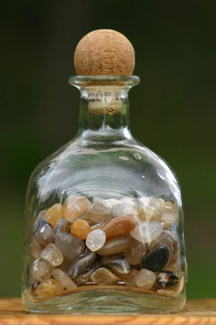 Glasflasche mit bunten Steinen