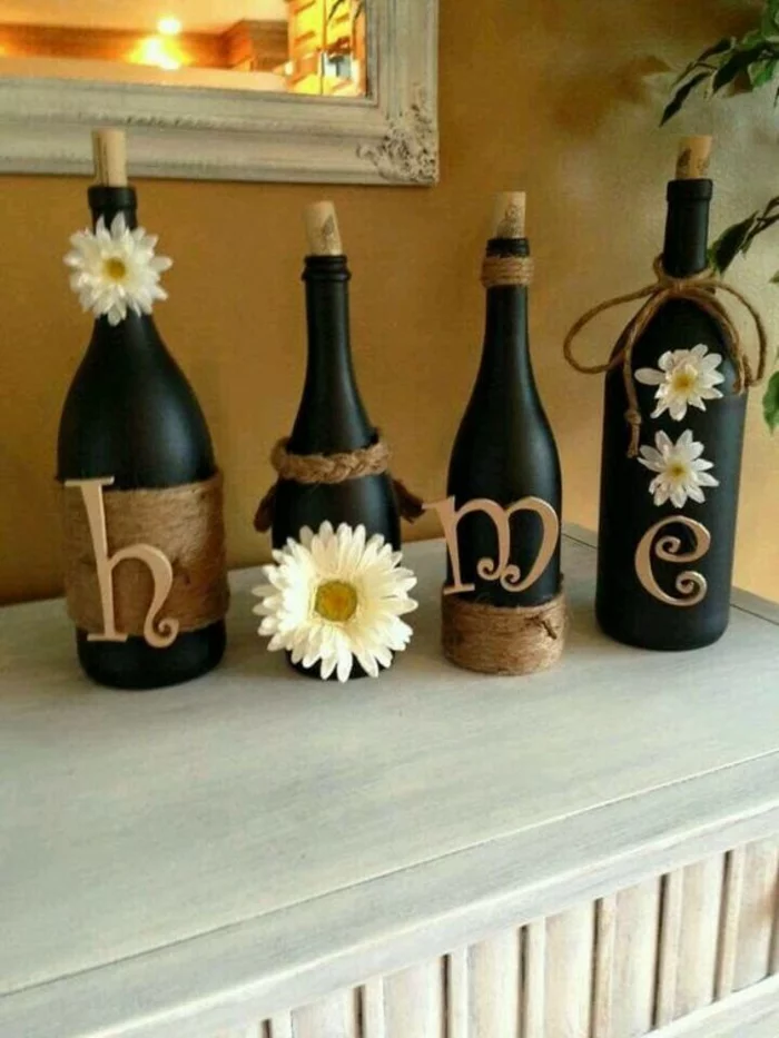 schwarze Flaschen, mit weißen Blumen dekoriert
