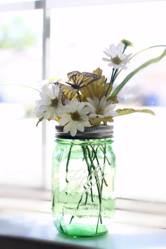grünes Einmachglas mit Blüten