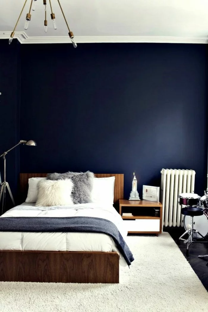 schlafzimmer blau dunkelblaue wände weißer teppich holzmöbel