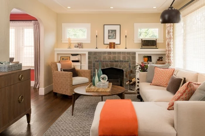 schönes wohnzimmerorange akzente stilvoller teppich kamin beige wände