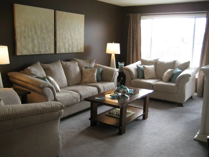 braunes Wohnzimmer mit beigen Möbeln, Wandbildern und hellem Teppichboden