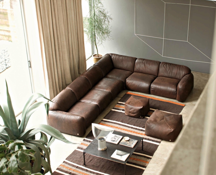 wohnideen wohnzimmer braunes sofa teppichläufer streifen braunnuancen