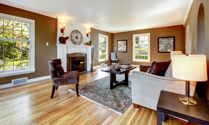 modernes Wohnzimmer mit braunen Wänden, weißem Kaminsims und Vintage Teppich