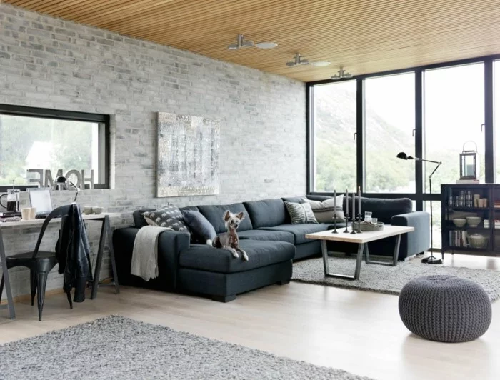 Wohnzimmer gestalten mit grauem Sofa und Ziegelwand in hellem Grau