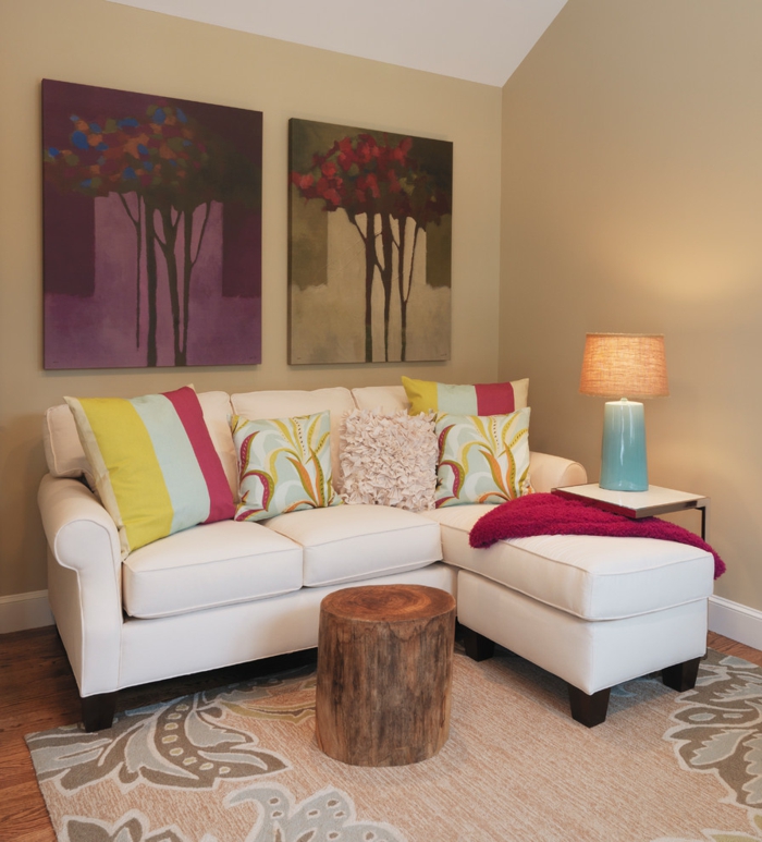 wohnzimmer beige helle wände weißes sofa rustikaler couchtisch floraler teppich