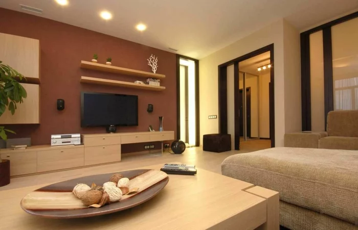 modernes Wohnzimmer mit brauner Akzentwand und hellen Holzmöbeln