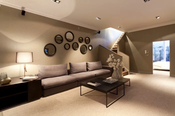 Wohnzimmer in Braun mit einem hellen Teppichboden und Wandspiegeln