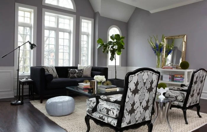 Wohnzimmer gestalten - graue Wände, dunkelgraues Sofa und gepolsterte Sessel