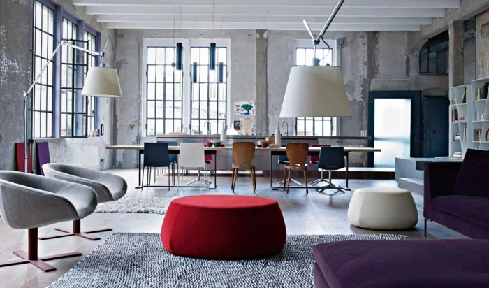 industrielles Wohnzimmer in Grau mit rotem Couchtisch und Sofa in Lila
