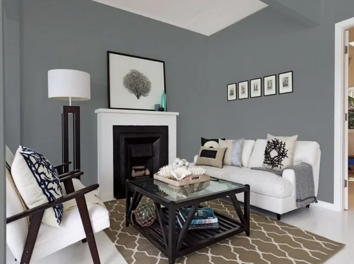 kleiner Wohnbereich mit grauer Wandfarbe, weißen Sesseln und gemustertem Teppich