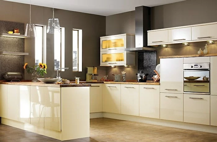 cremefarbene Küchenschränke mit glänzender Oberfläche, braune Wände und Akzente mit Mosaikfliesen