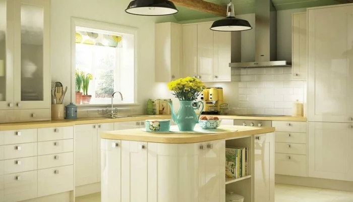 moderne Küche mit hellgrüner Decke, cremefarbenen Küchenschränken und hellen Bodenfliesen 