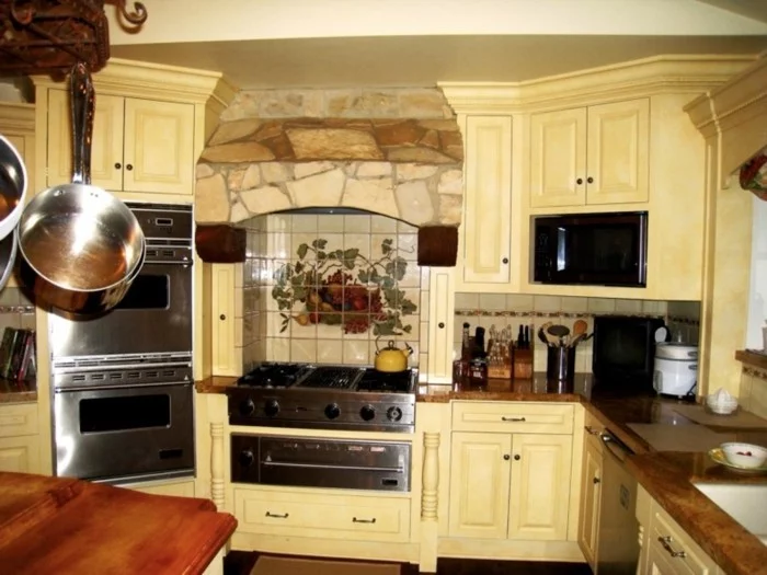 kleine Küche mit cremefarbenen Küchenschränken und Mosaikfliesen